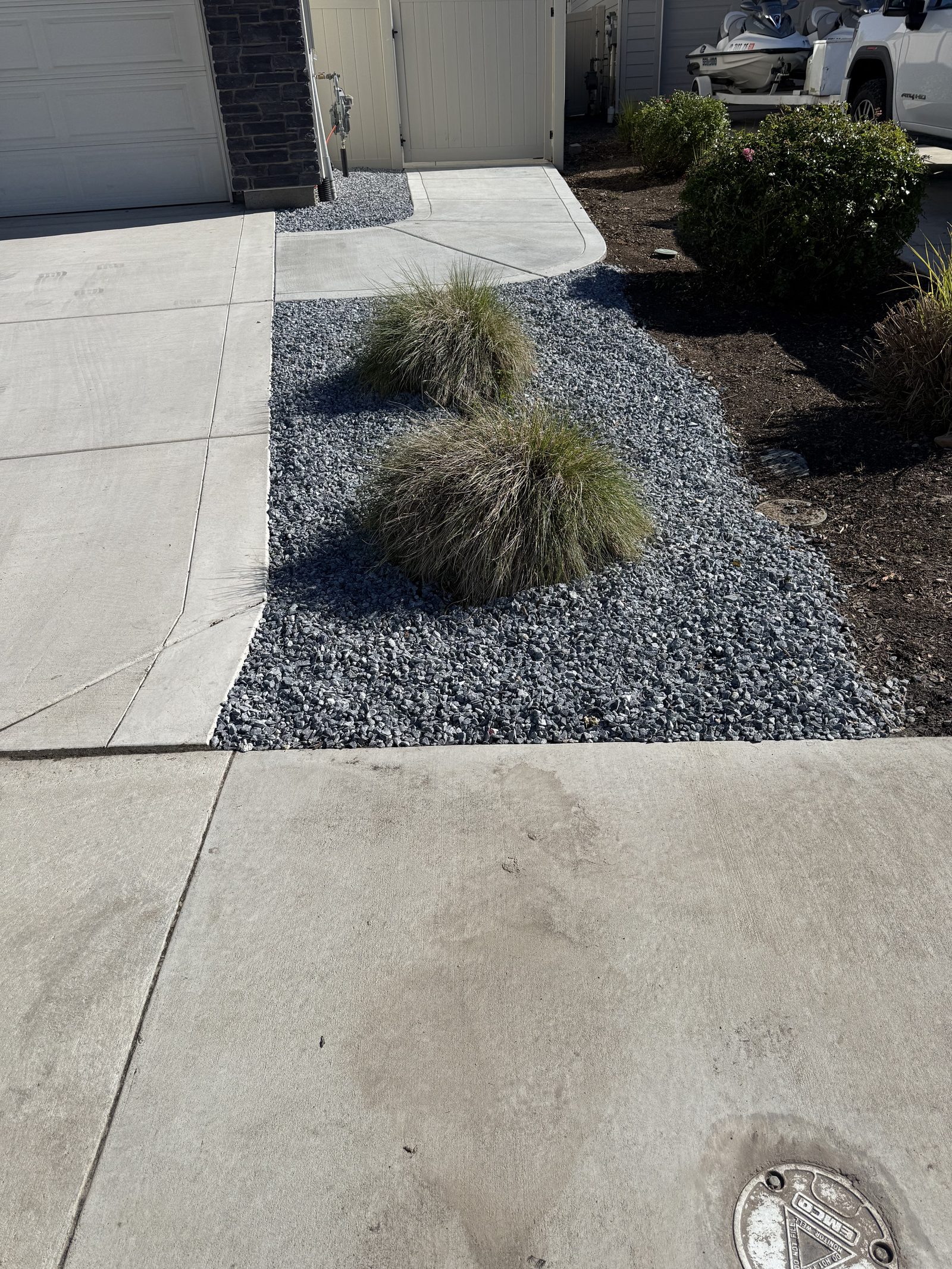 Finished front yard gravel beds with ornamental shrubs
